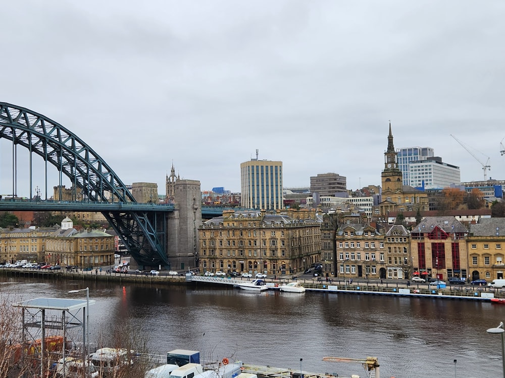 a bridge over a river with a city in the background