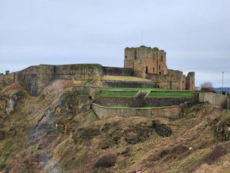 a castle on top of a hill with a flag on it in Tynemouth