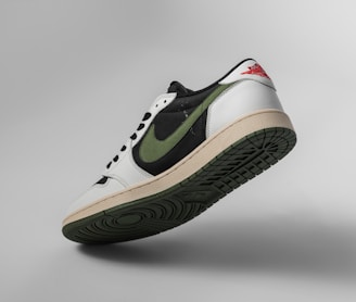 a pair of white and green sneakers on a gray background