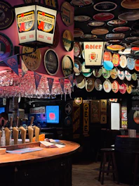 a bar with a bunch of beer glasses hanging from the ceiling