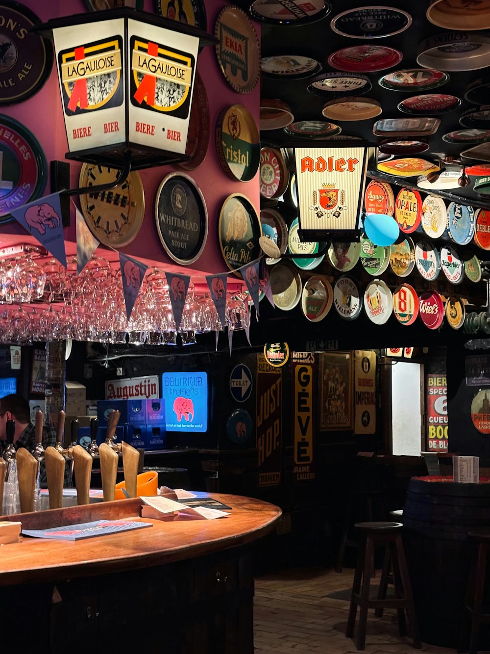 a bar with a bunch of beer glasses hanging from the ceiling