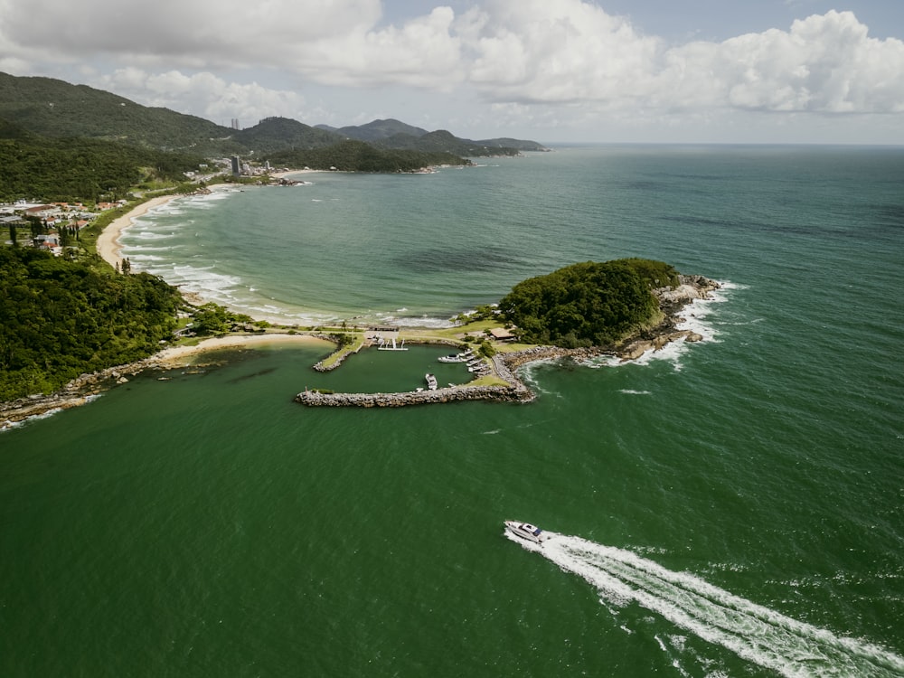 an aerial view of an island with a boat in the water