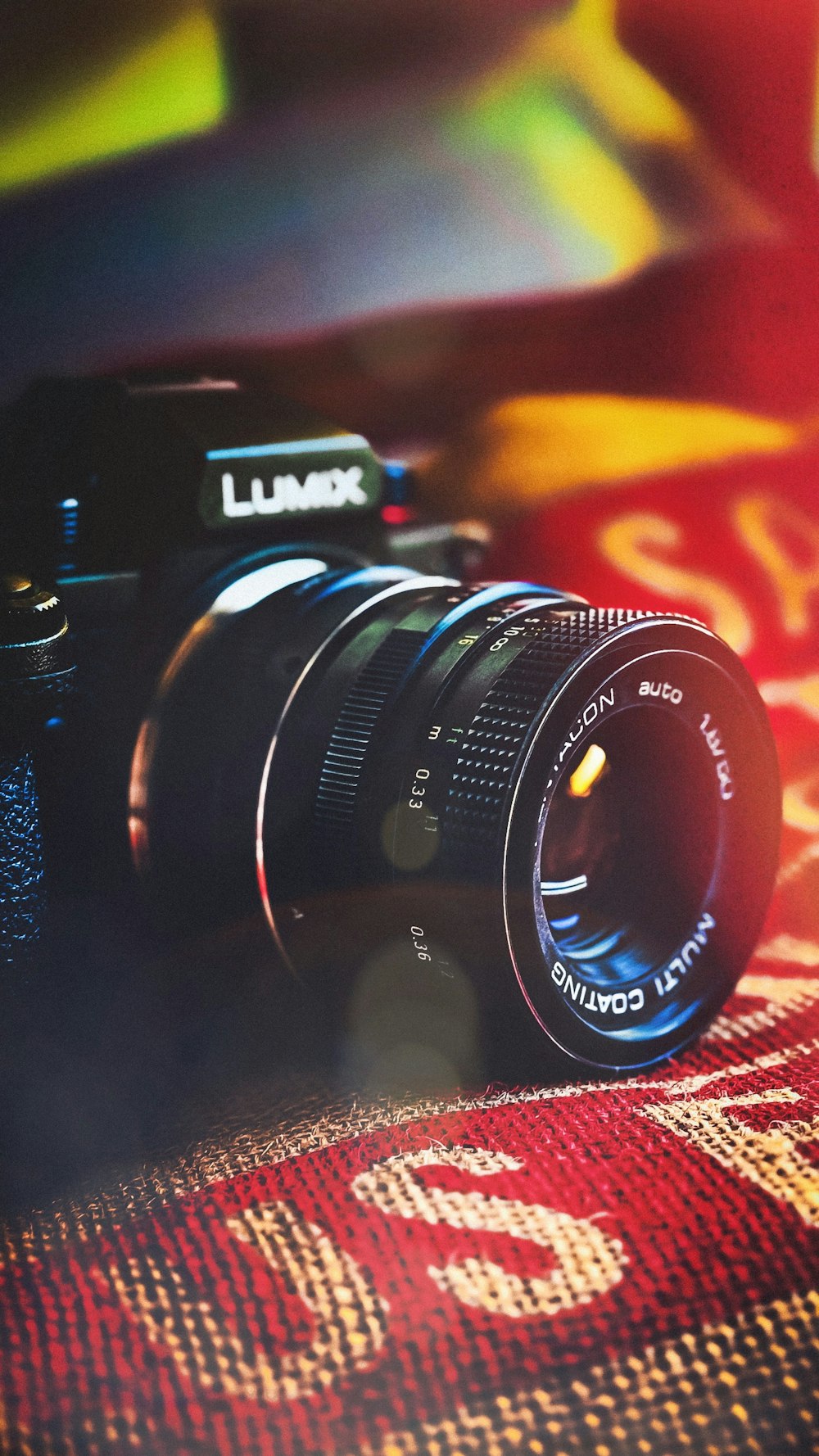 a camera sitting on top of a colorful blanket