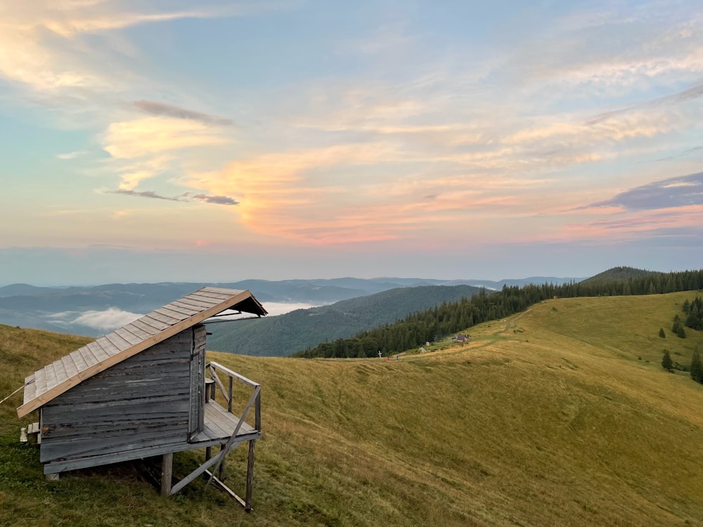 a wooden structure sitting on top of a lush green hillside