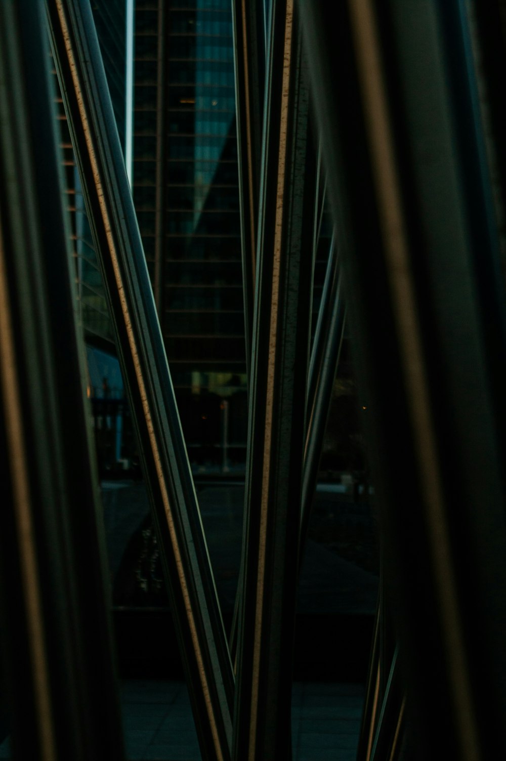 a close up of a metal structure with a building in the background