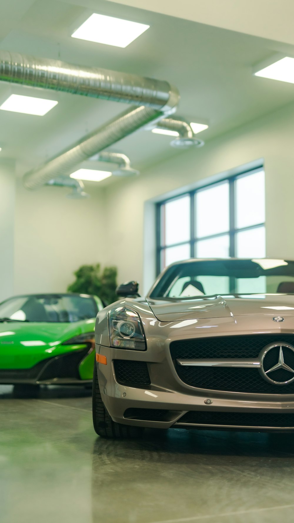 a mercedes benz sports car and a green mercedes benz sports car in a showroom
