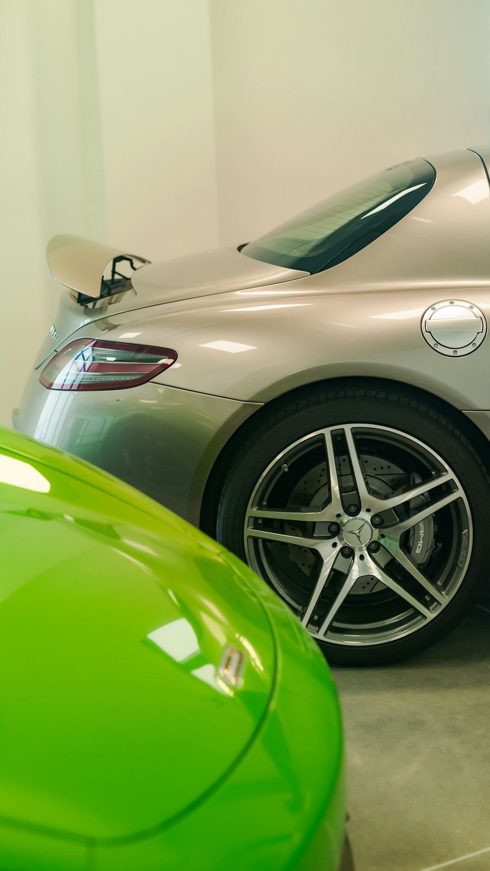a silver sports car parked next to a green sports car