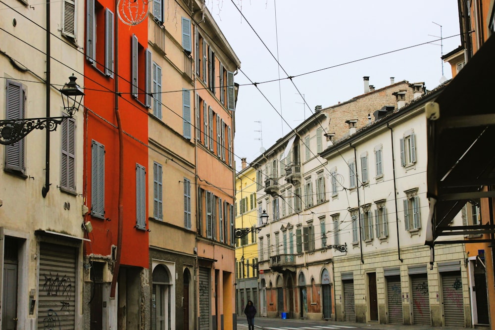 a person walking down a street next to tall buildings