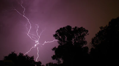 a purple sky with a lightning bolt in the middle of it