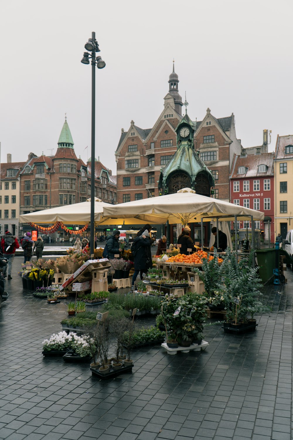 an outdoor market with a clock tower in the background