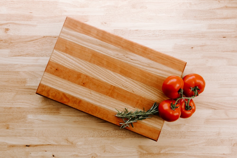 a cutting board with tomatoes on top of it