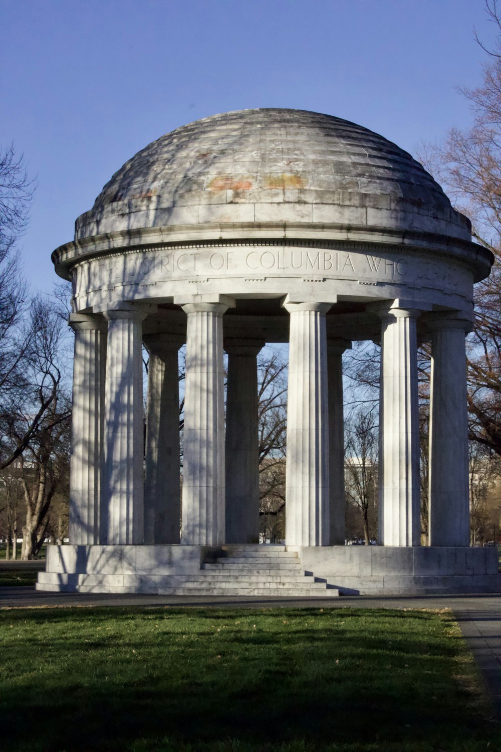 a large white monument sitting on top of a lush green field