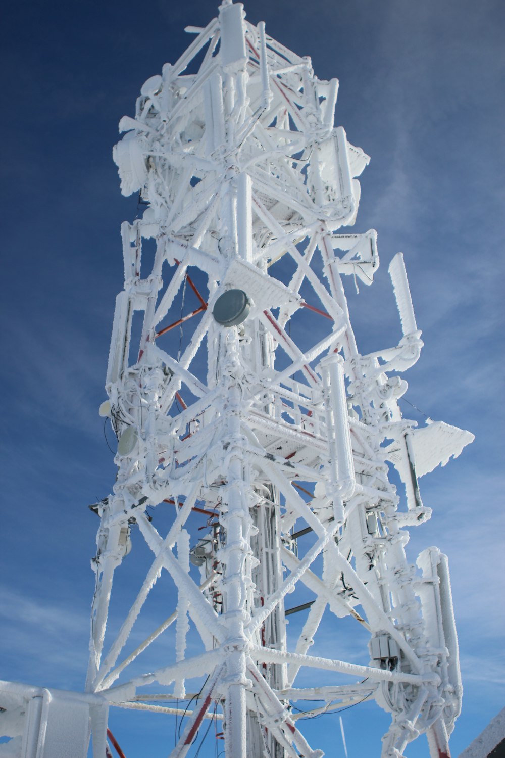 uma torre branca muito alta com muitos fios em cima dela