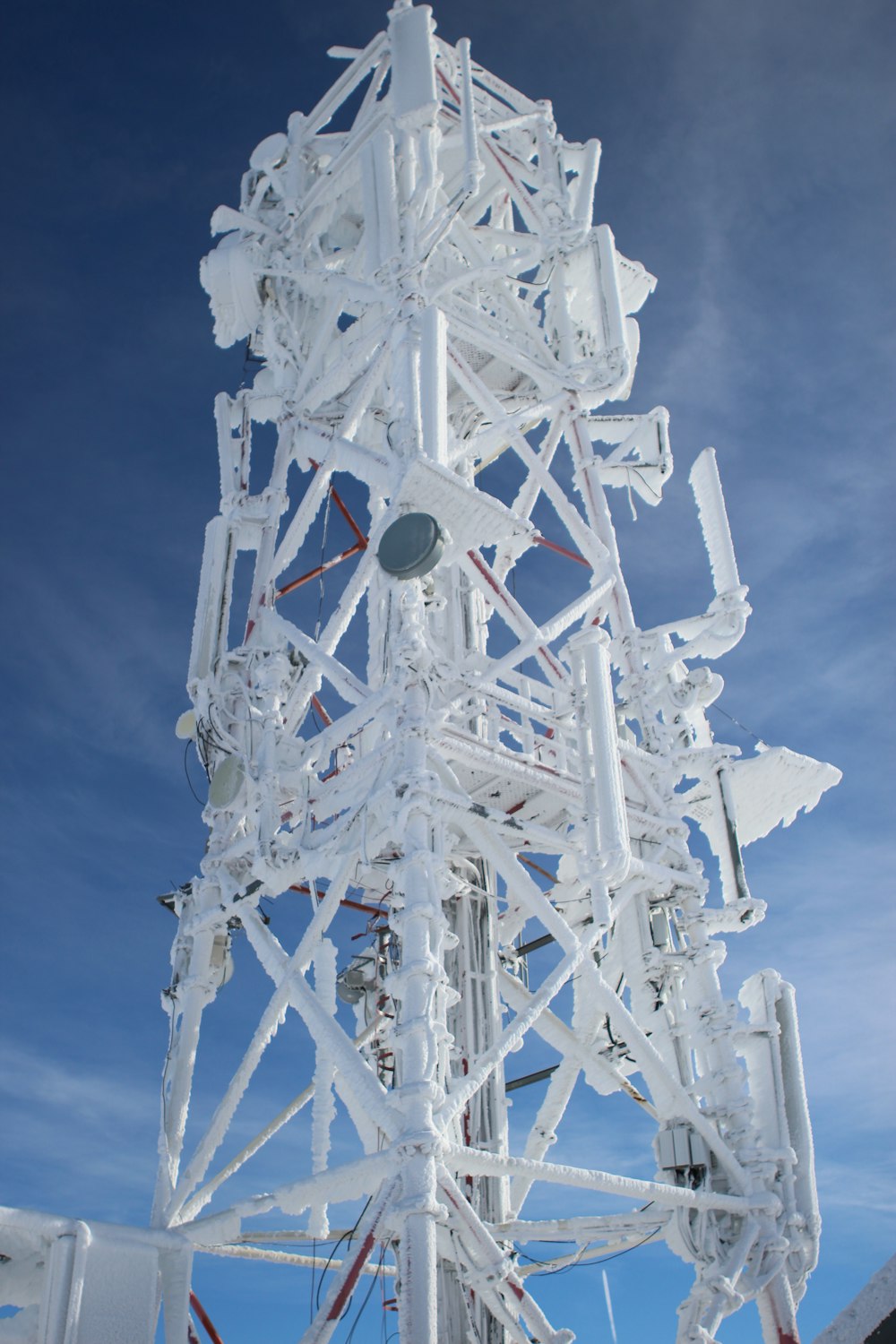 una torre bianca molto alta con un sacco di fili in cima
