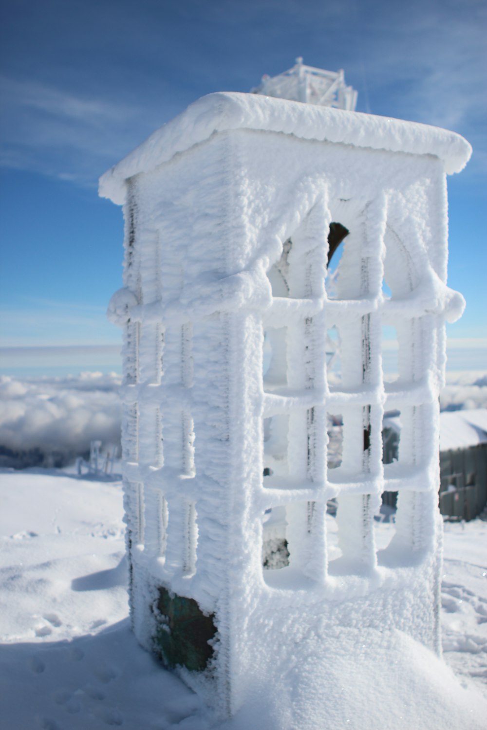 a snow covered structure on top of a snow covered mountain