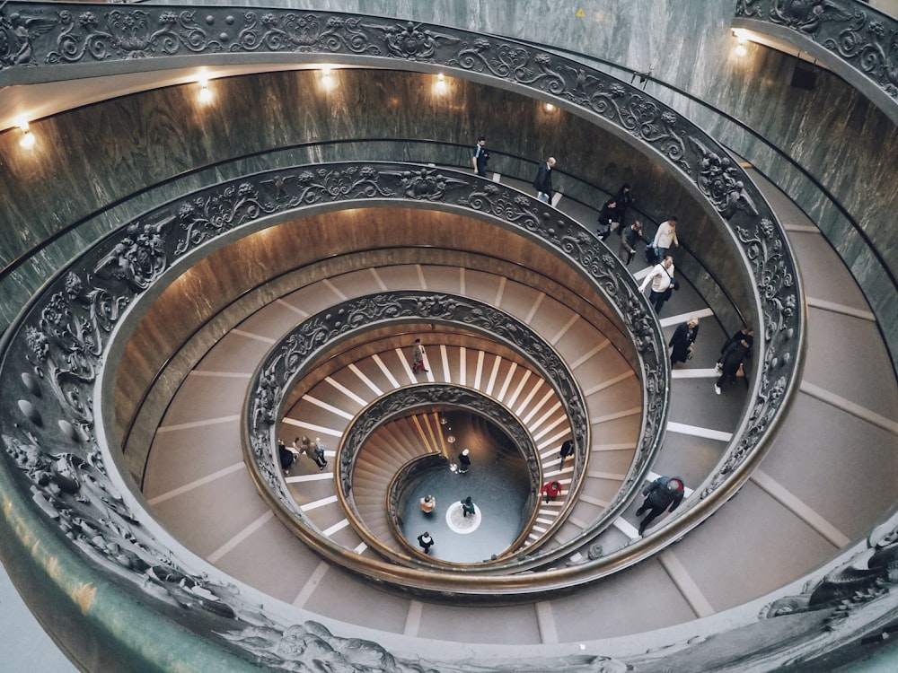 a group of people walking up and down a spiral staircase