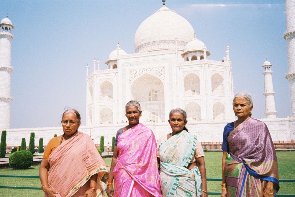 Un grupo de mujeres de pie frente a un edificio blanco