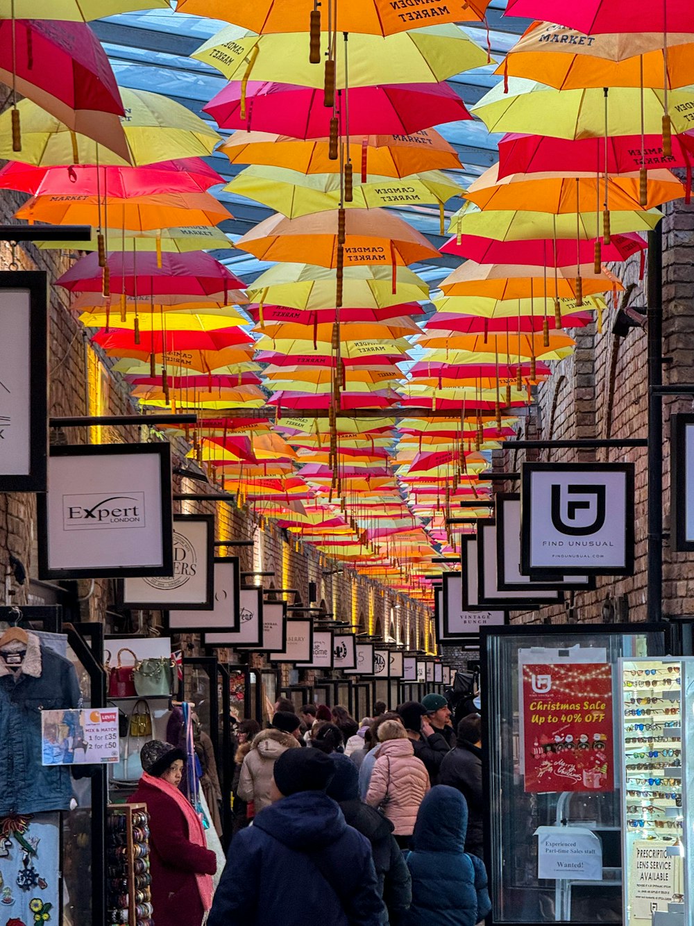 a group of people walking down a street under colorful umbrellas