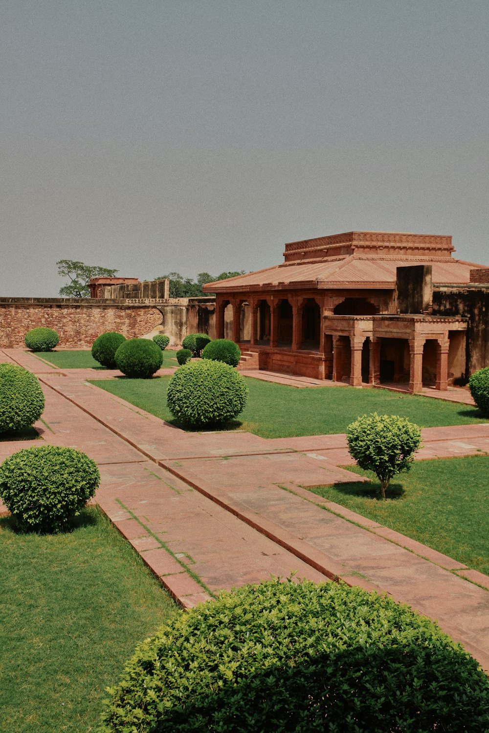 a building with a lot of green bushes in front of it