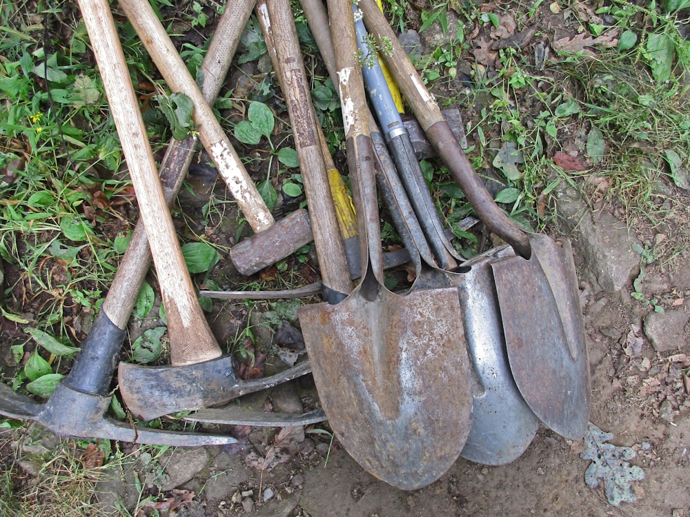 a pile of shovels and forks laying on the ground
