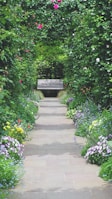 a park bench surrounded by flowers and greenery