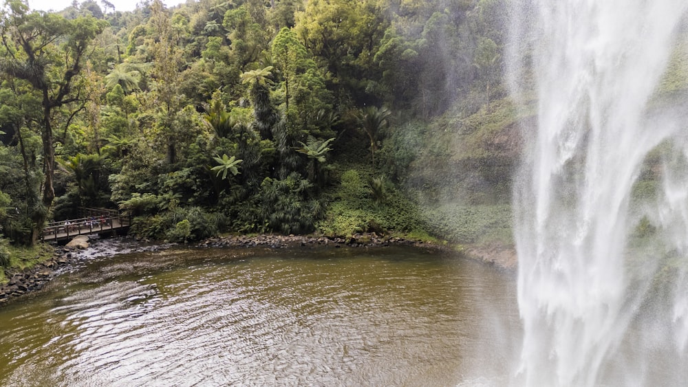 a large waterfall with a bridge over a body of water