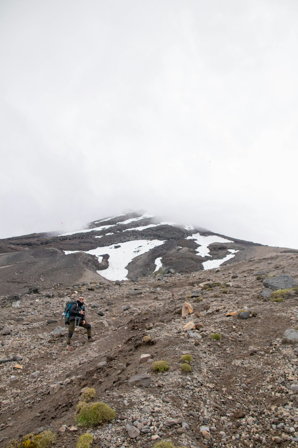 Un hombre subiendo una montaña con una mochila