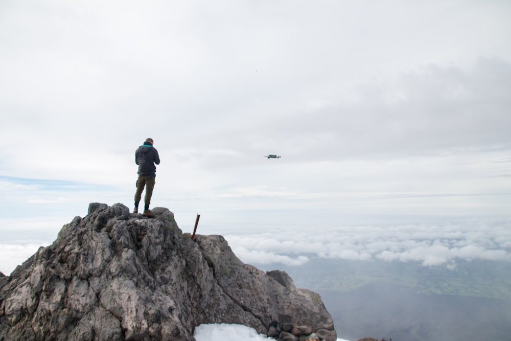 a man standing on top of a large rock