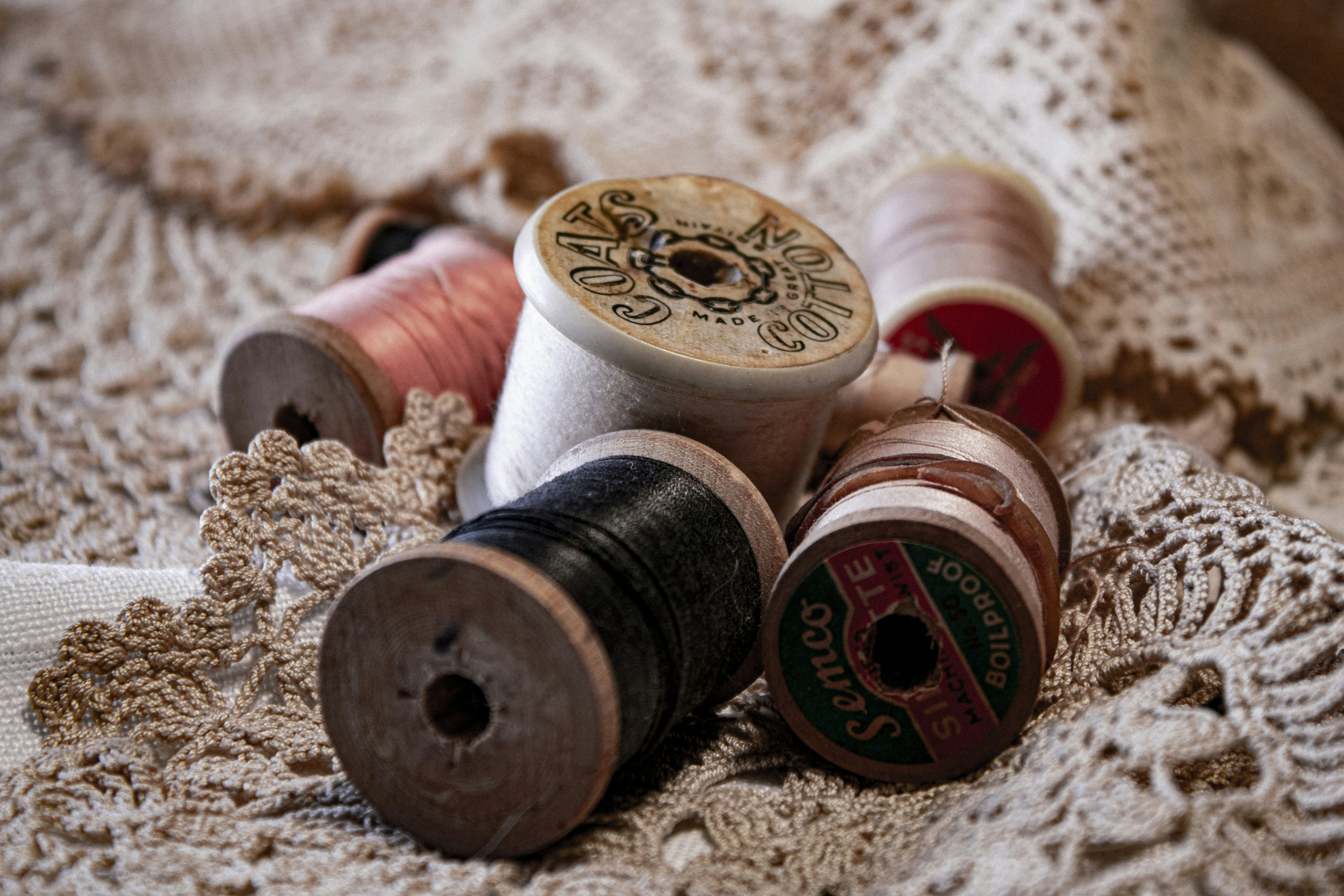 a pile of spools of thread sitting on top of a blanket