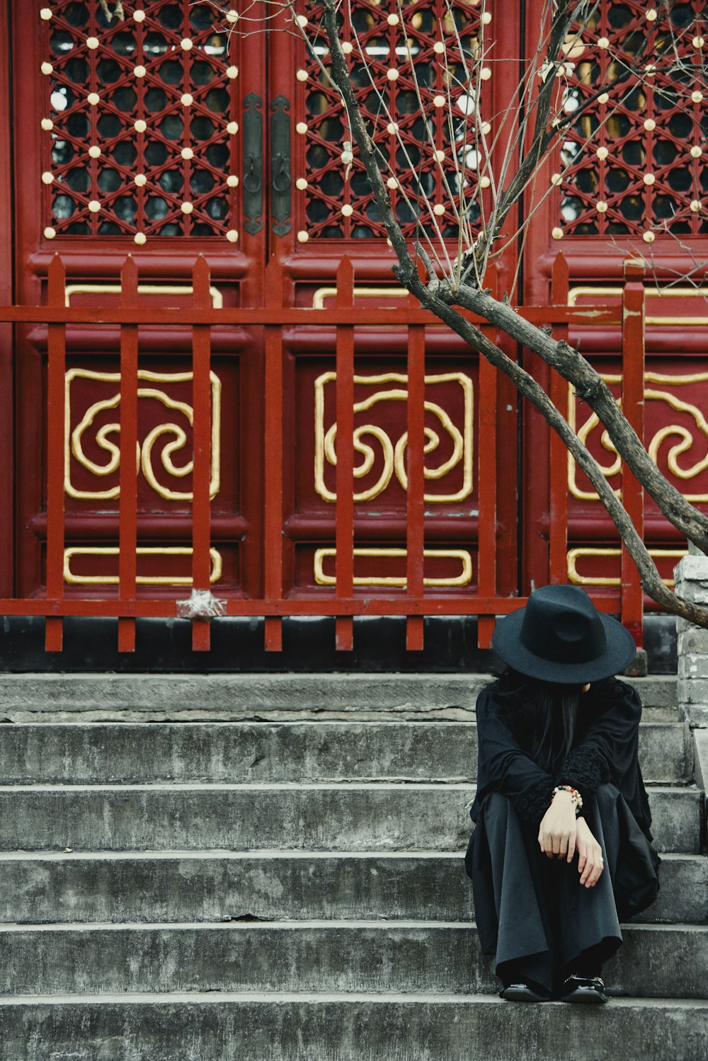 a person sitting on some steps with a hat on