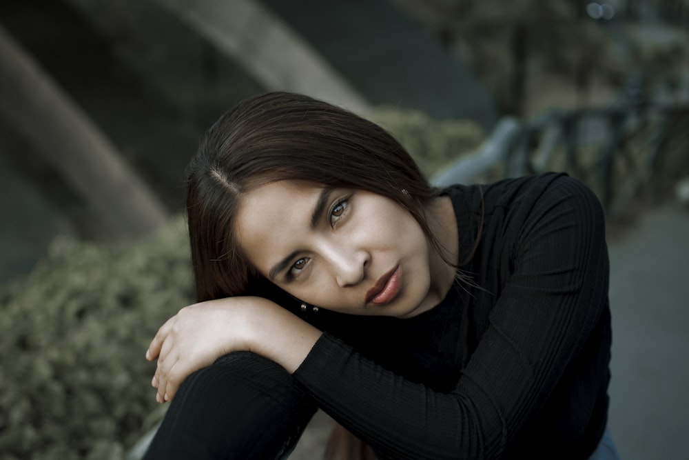 a woman sitting on a bench with her arms crossed