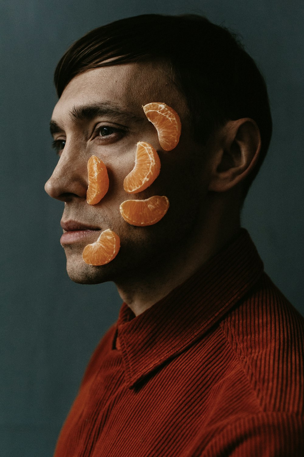 Ein Mann mit Orangenscheiben im Gesicht