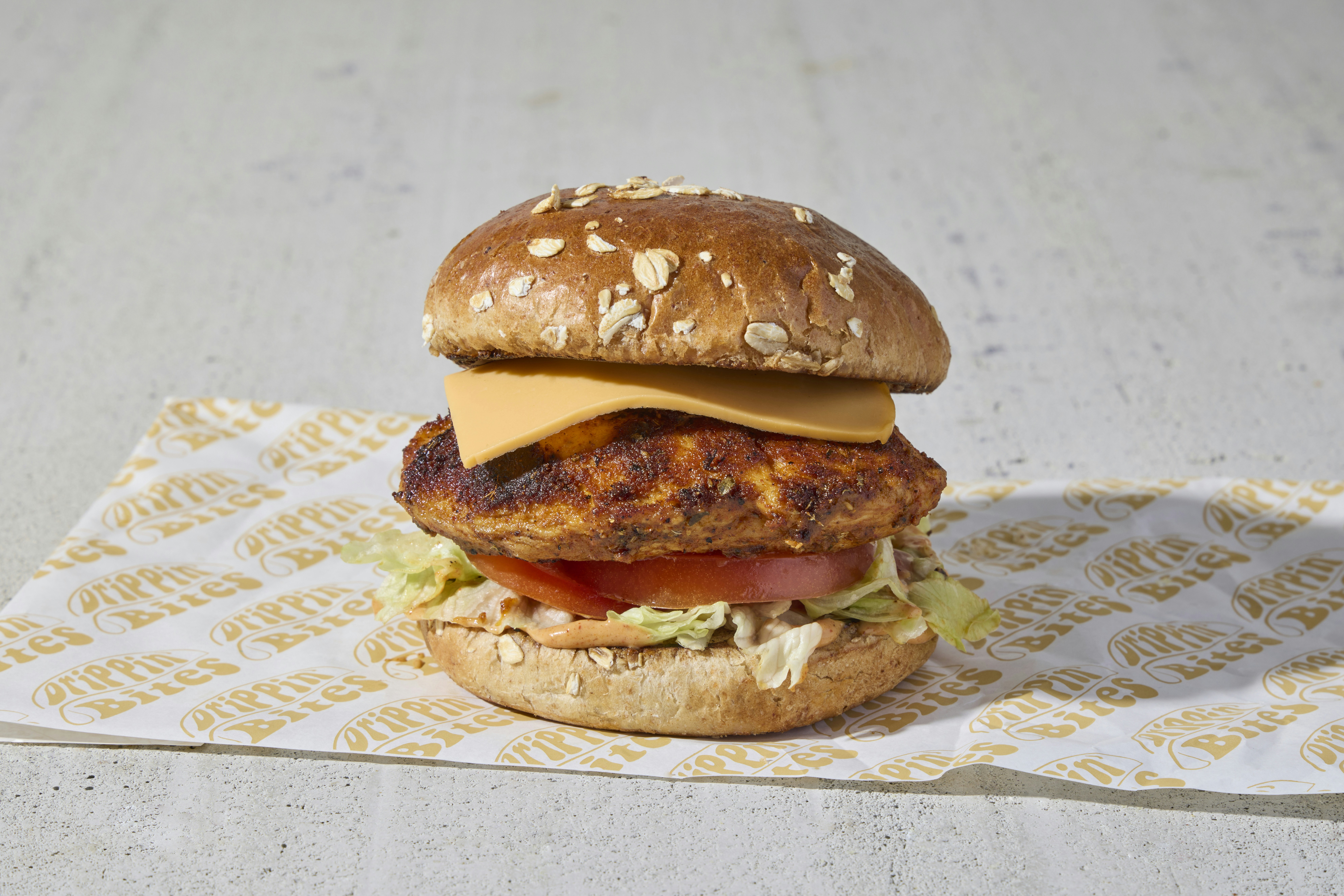 a chicken sandwich with lettuce, tomato, and cheese