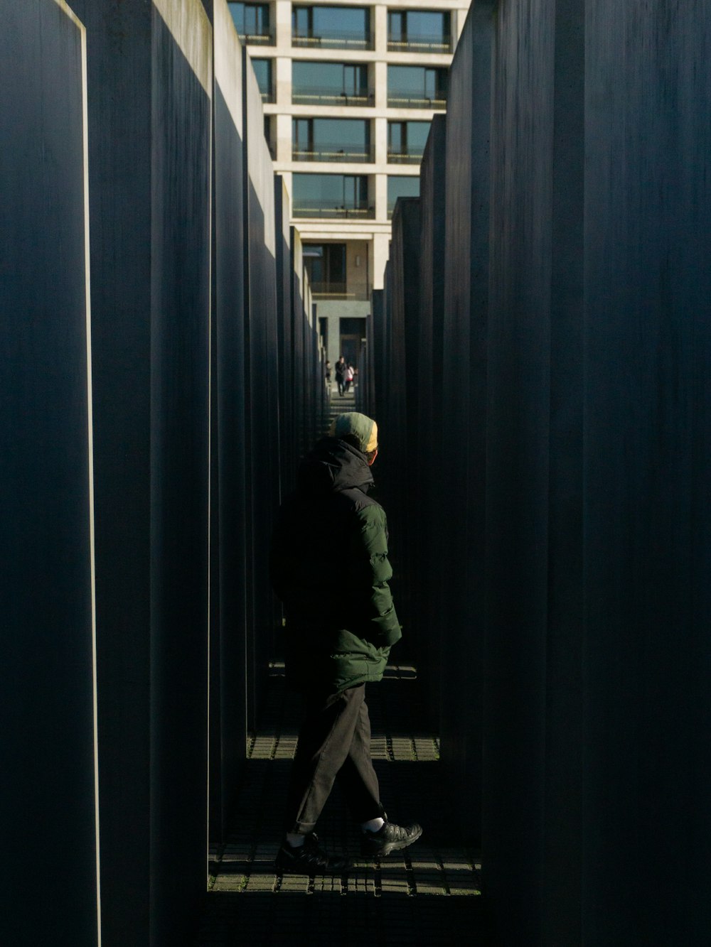 a man walking through a tunnel of black metal