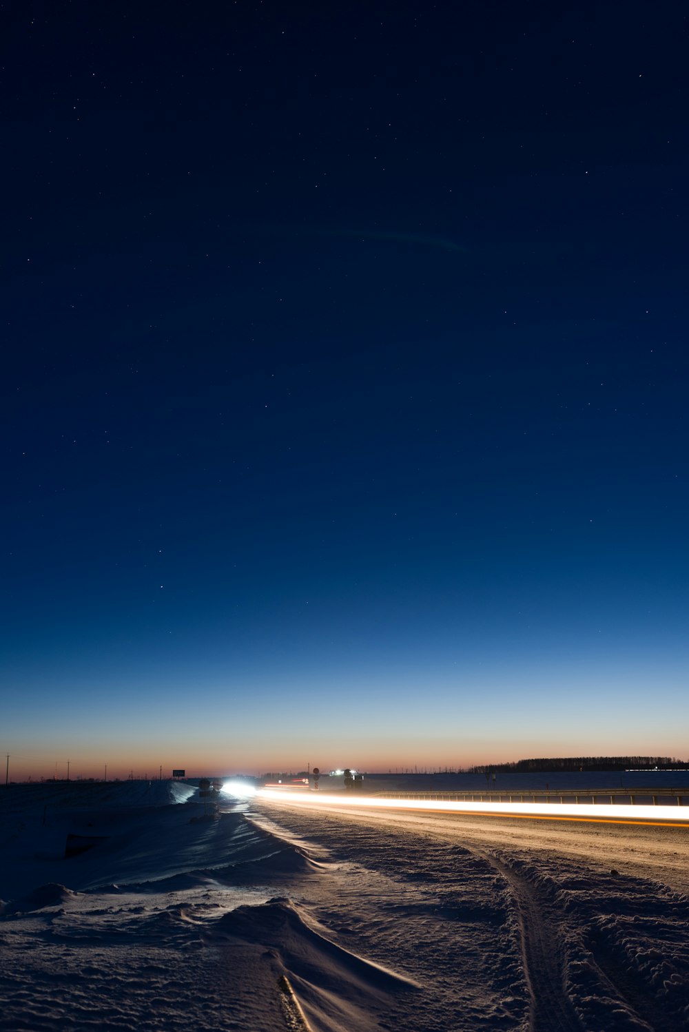 a car driving down a snowy road at night