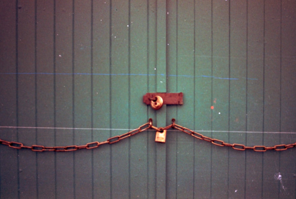 a chain and padlock attached to a green door