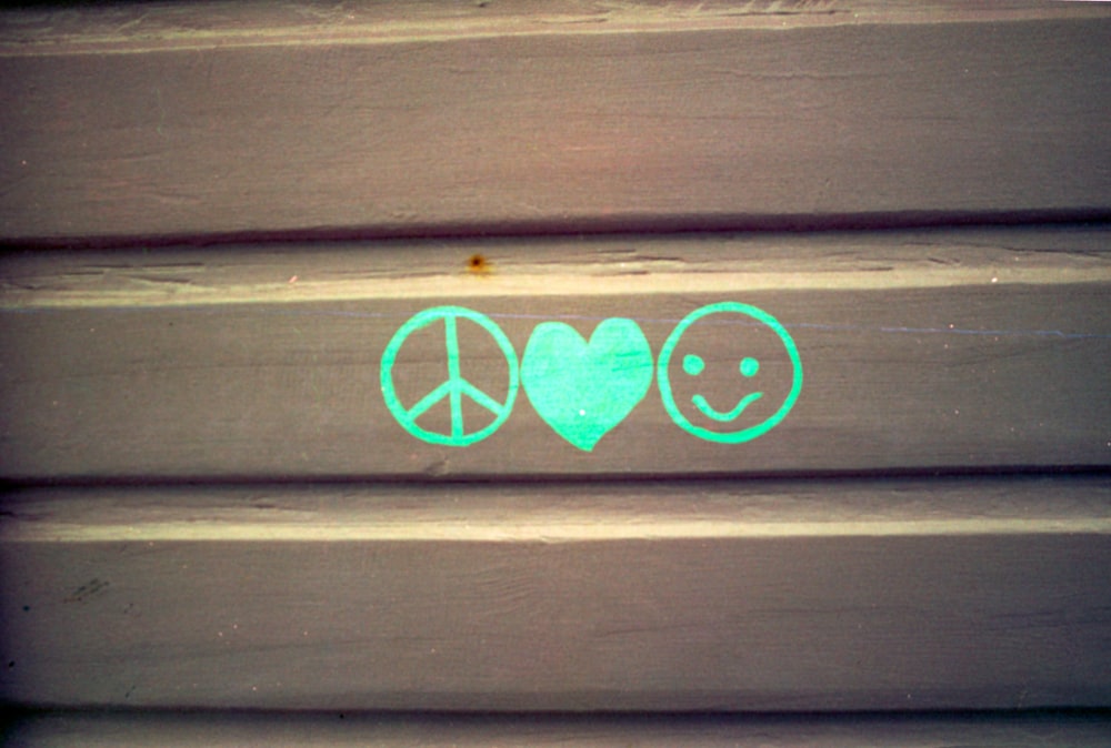 a peace and love sign painted on a wooden wall