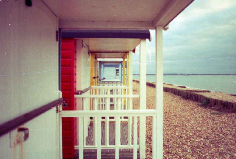 a red and white building sitting on top of a beach