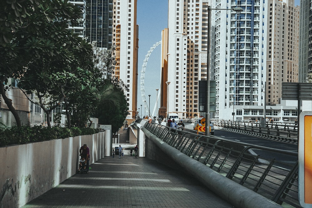 a man riding a bike down a sidewalk next to tall buildings