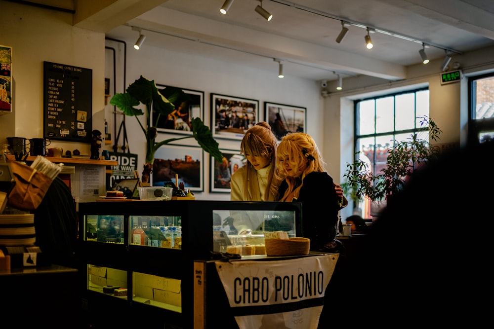 a couple of women standing at a counter in a restaurant