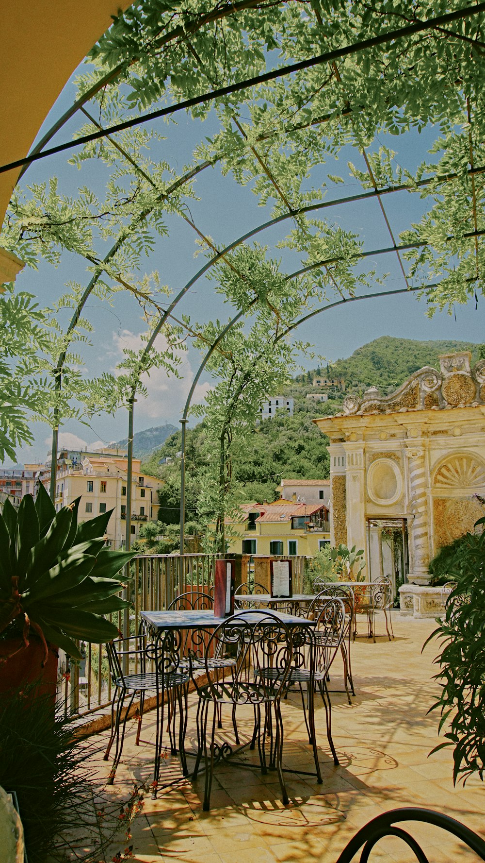 a painting of a patio with tables and chairs