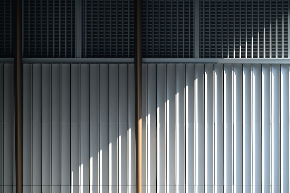 a white wall with vertical blinds on it