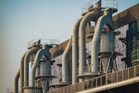 a row of pipes on a building with a sky background