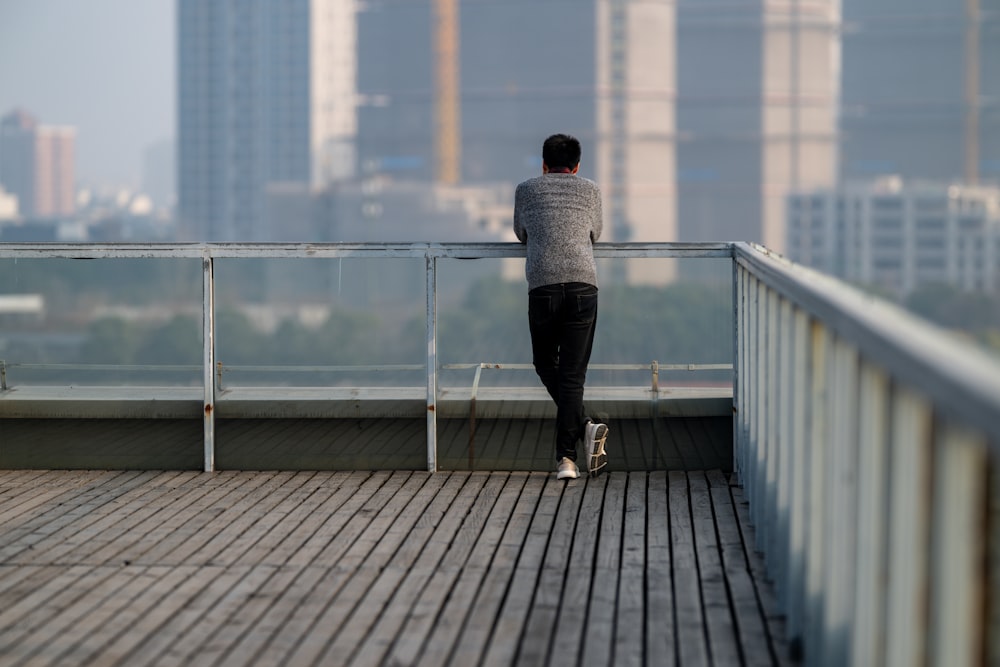 a person standing on a bridge with a city in the background