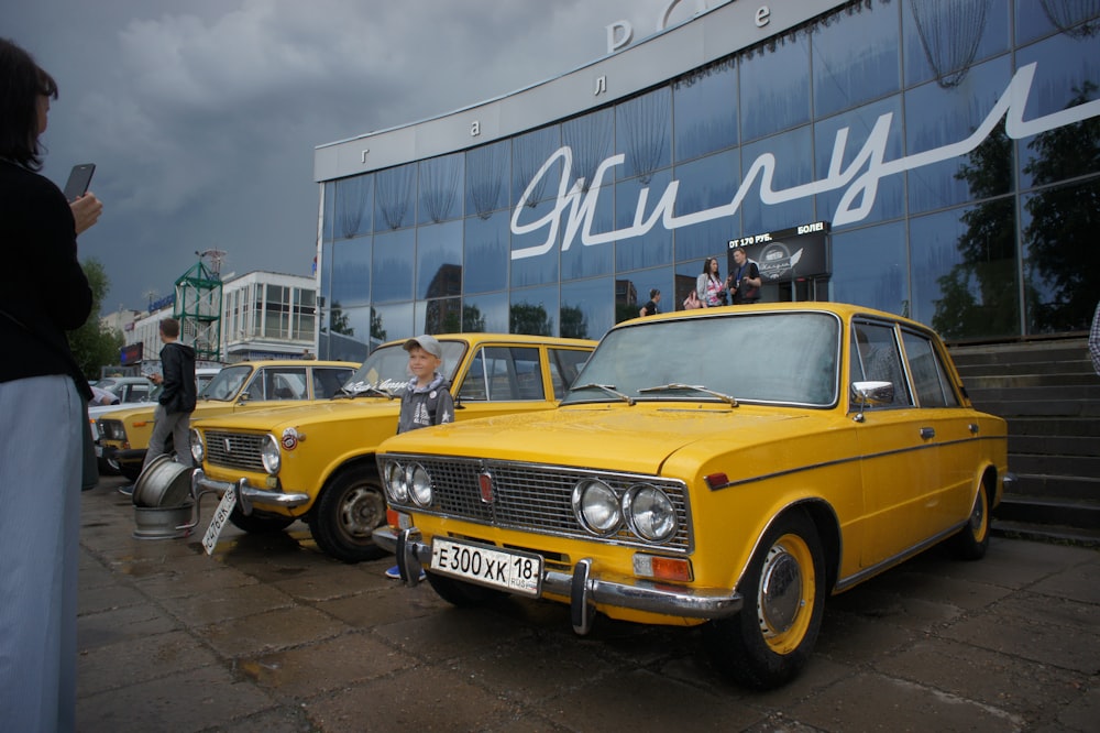 um grupo de carros antigos estacionados em frente a um prédio