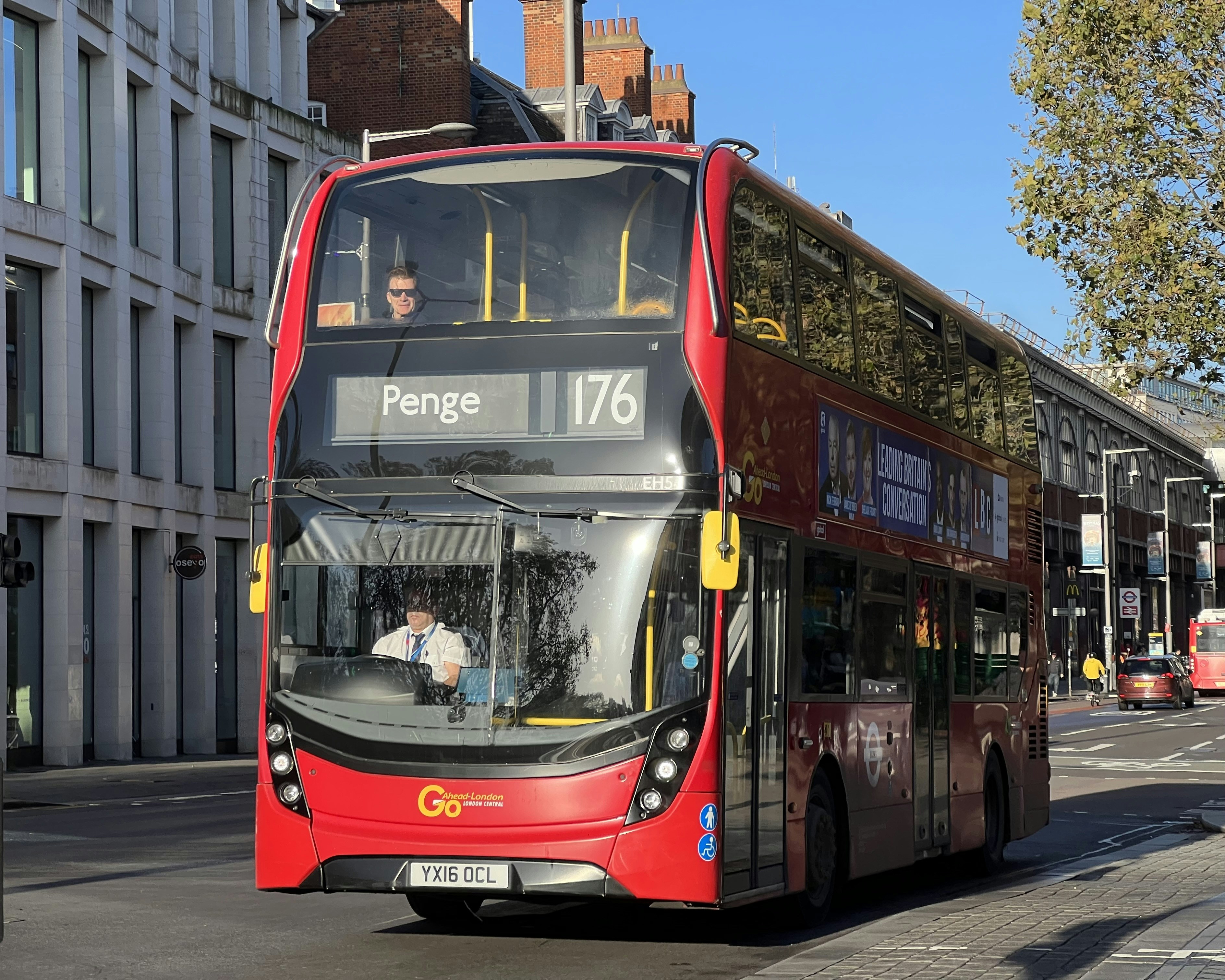 a red double decker bus driving down a street