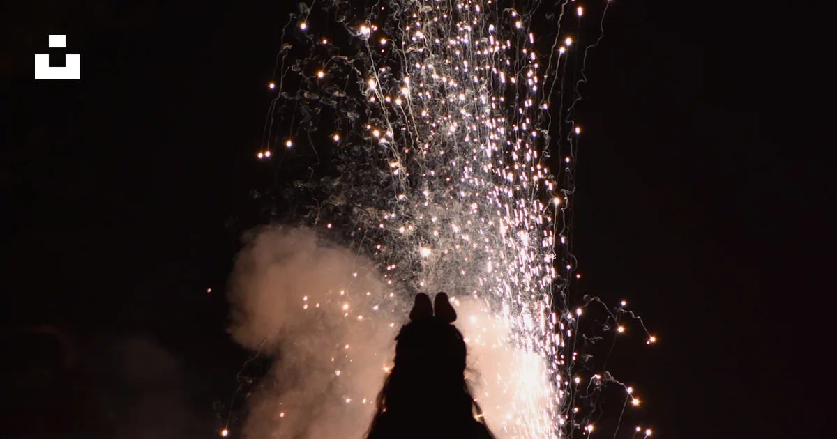 A woman standing in front of a firework display photo – Free Fireworks ...