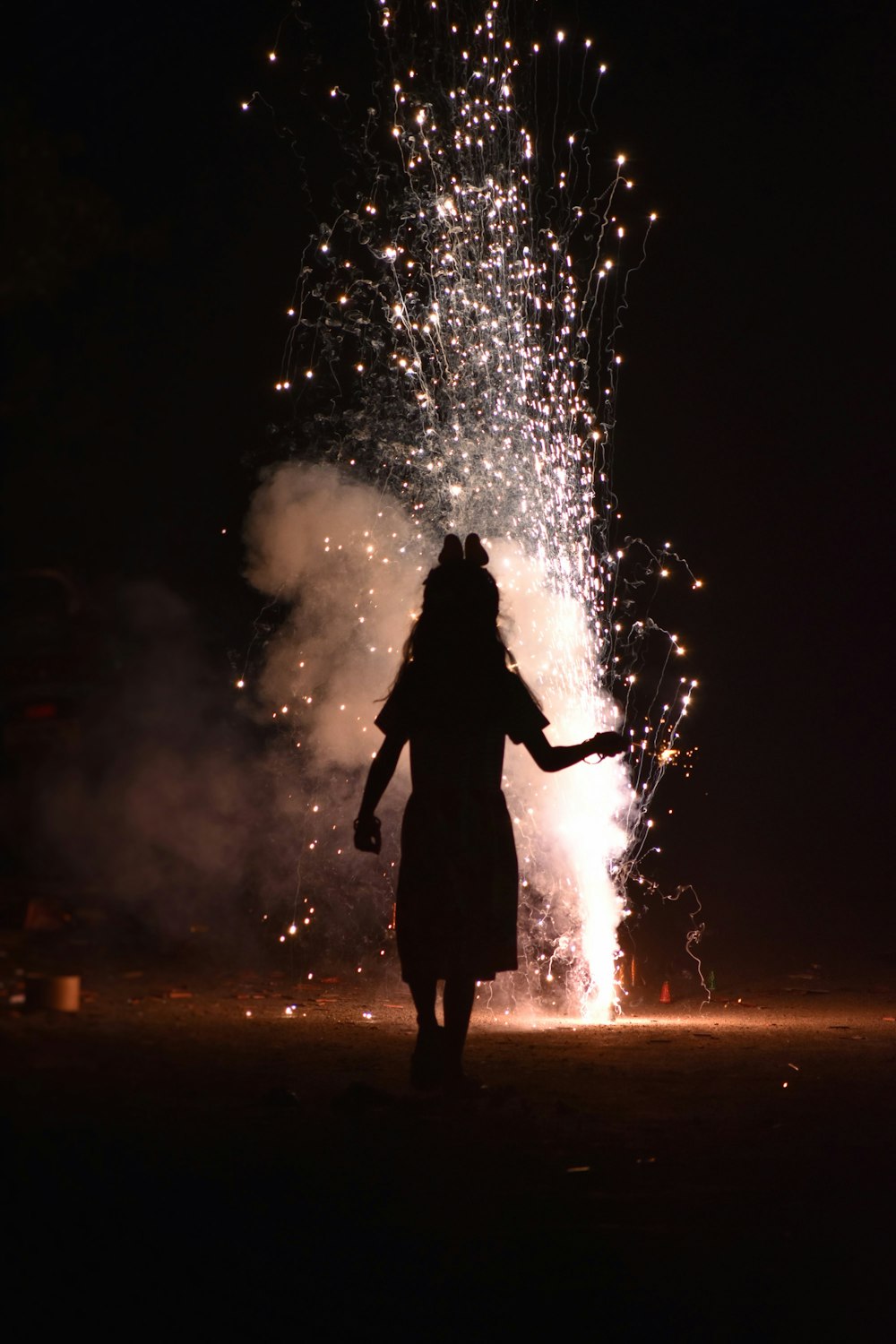 a woman standing in front of a firework display
