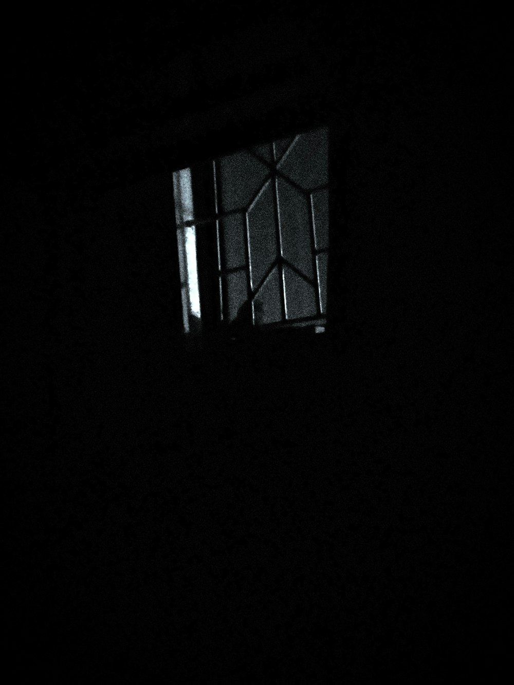 a window in a dark room with a light coming through it