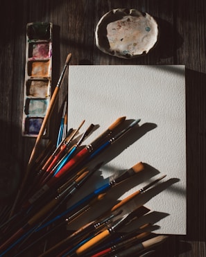 a bunch of paint brushes sitting on top of a paper
